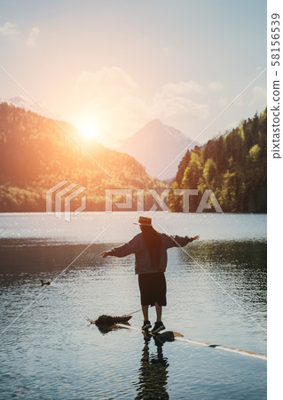 The girl in the dress and hat of the lake in the mountains 58156539