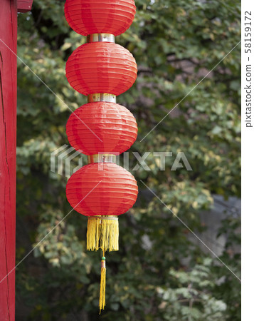 Hanging red lantern on the tree leaf background Hanging red lantern on the tree leaf background 58159172