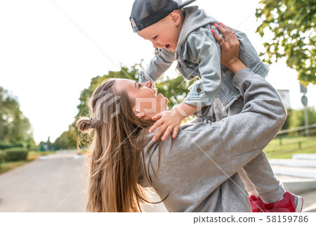 Young happy family smiling rejoicing having fun, mom throws up little boy 3-5 years old child, relax Young happy family smiling rejoicing having fun, mom throws up little boy 3-5 years old child, relax 58159786