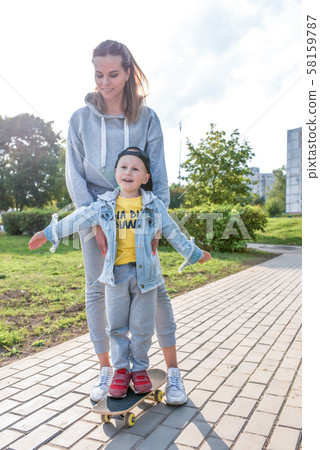 Young happy family smiling rejoicing, mom trains little boy 3-5 years old child, learns first Young happy family smiling rejoicing, mom trains little boy 3-5 years old child, learns first 58159787