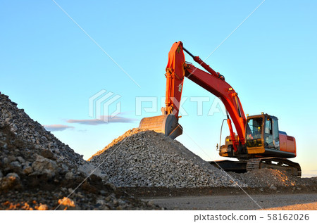 Large tracked excavator works in a gravel pit. Large tracked excavator works in a gravel pit. 58162026