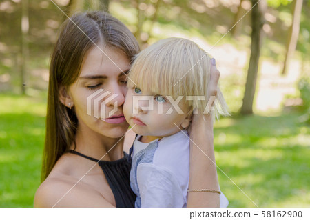 Very sad mom and little son in her arms in the Very sad mom and little son in her arms in the 58162900