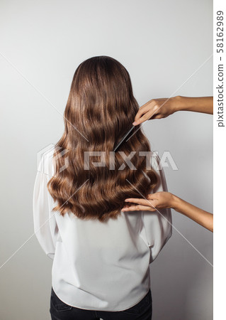 Closeup of female hands of hairdresser or coiffeur makes hairstyle. Hair Closeup of female hands of hairdresser or coiffeur makes hairstyle. Hair 58162989
