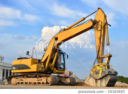 Excavator with crusher bucket for crushing concrete. Construction waste recycling Excavator with crusher bucket for crushing concrete. Construction waste recycling 58163685