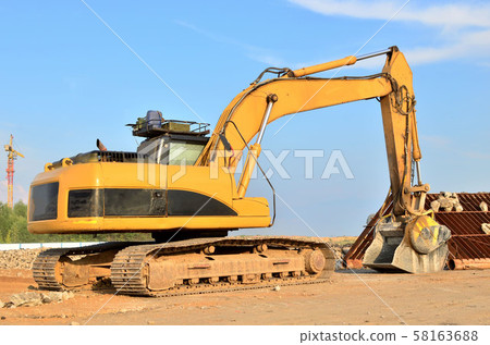 Excavator with crusher bucket for crushing concrete. Construction waste recycling Excavator with crusher bucket for crushing concrete. Construction waste recycling 58163688