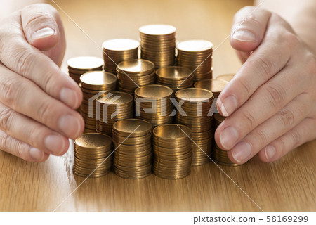 Hands with stacked gold coins 58169299