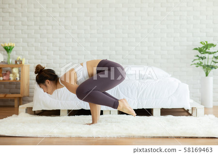 Athletic Asian woman practice yoga yoga Baby Crow or Baby Bakasana pose to meditation in bedroom after wake up in the morning Feeling so comfortable and relax,Healthcare Concept Athletic Asian woman practice yoga yoga Baby Crow or Baby Bakasana pose to meditation in bedroom after wake up in the morning Feeling so comfortable and relax,Healthcare Concept 58169463