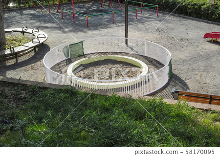 Park with sandbox surrounded by fence 58170095