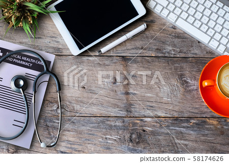 Stethoscope,heart,pen,laptop,mouse and cup of coffee on wooden table background desk.Top view with copy space. 58174626