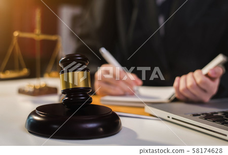Justice and law concept.Male judge in a courtroom the gavel, working with digital tablet computer on wood table in sun light. Justice and law concept.Male judge in a courtroom the gavel, working with digital tablet computer on wood table in sun light. 58174628