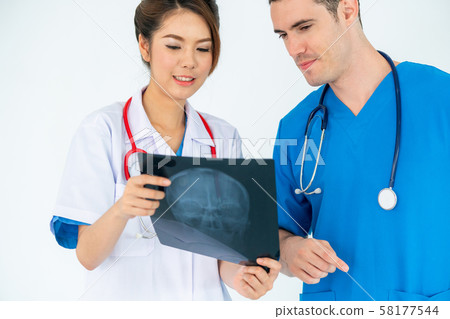 Doctors working with x ray film of patient head. 58177544