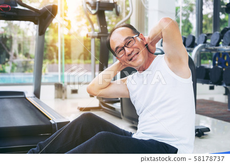 Senior man do body stretching in fitness center. 58178737