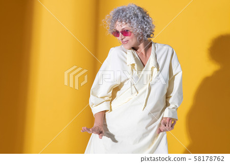 Mature woman wearing long dress moving and dancing Mature woman wearing long dress moving and dancing 58178762