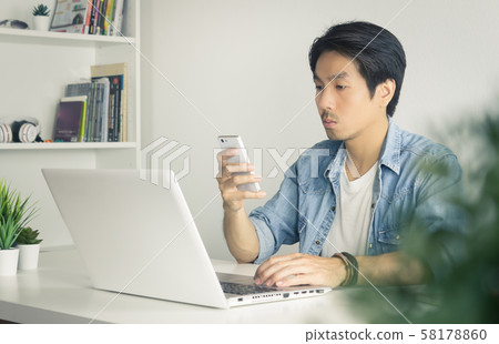 Portrait Asian Casual Businessman Checking Mail and Chat with Colleague by Smartphone in Vintage Tone Portrait Asian Casual Businessman Checking Mail and Chat with Colleague by Smartphone in Vintage Tone 58178860