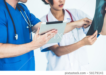 Doctors working with x ray film of patient head. 58179141