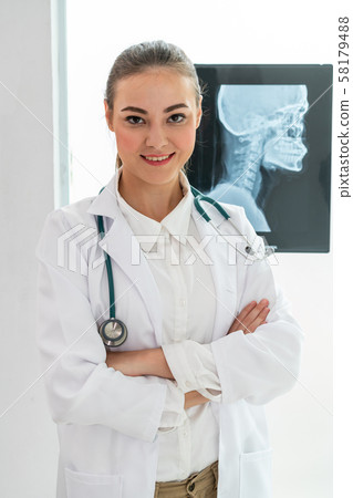 Doctor working with x ray film of patient head. Doctor working with x ray film of patient head. 58179488