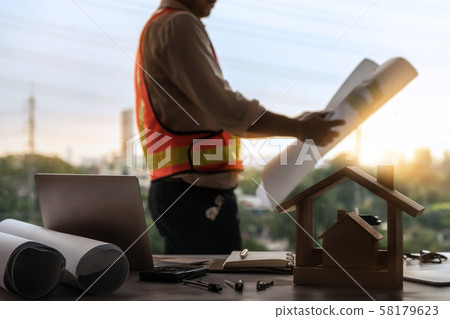Young man architect or engineer working at desk. 58179623