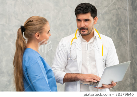 Doctor and nurse working with laptop computer. Doctor and nurse working with laptop computer. 58179640