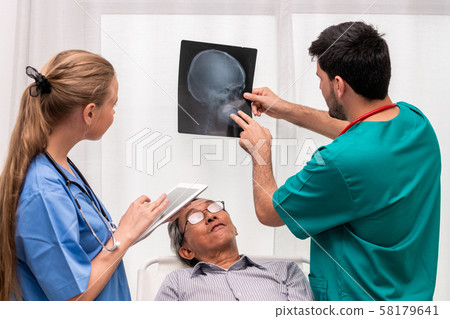 Doctor team work with x ray film image of patient. Doctor team work with x ray film image of patient. 58179641
