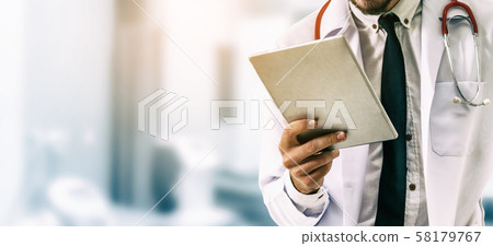 Doctor using tablet computer at the hospital. Doctor using tablet computer at the hospital. 58179767