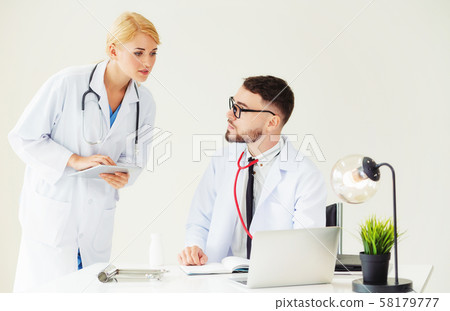 Doctor at hospital works on computer with partner. 58179777