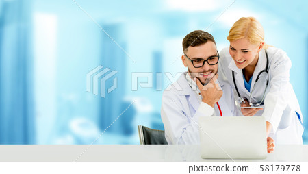 Doctors working with laptop computer in hospital. Doctors working with laptop computer in hospital. 58179778