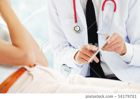 Male Doctor and Female Patient in Hospital Office 58179781