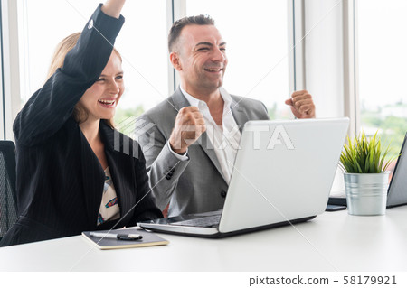 Businessman and businesswoman working in office. 58179921
