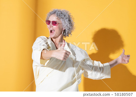 Woman showing thumbs up while feeling satisfied and excited 58180507