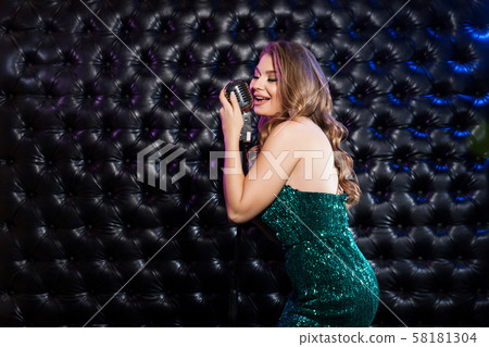 Beauty Woman with retro Microphone over dark Beauty Woman with retro Microphone over dark 58181304