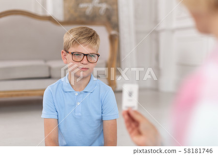 A little boy in a blue t-shirt and his mother sitting on floor and studying English words with cards 58181746
