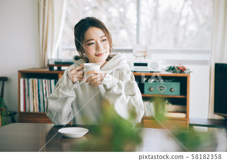 一個女人在一個房間裡喝咖啡 58182358