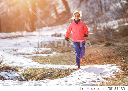 Young slim woman jogging in winter park Young slim woman jogging in winter park 58183483