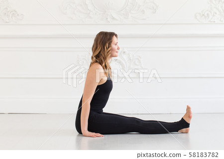 Beautifull sporty teen sits on white floor of gym 58183782