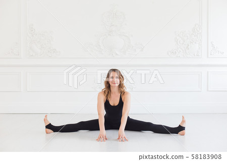 Cute teen touches the floor with her hands while doing splints Cute teen touches the floor with her hands while doing splints 58183908