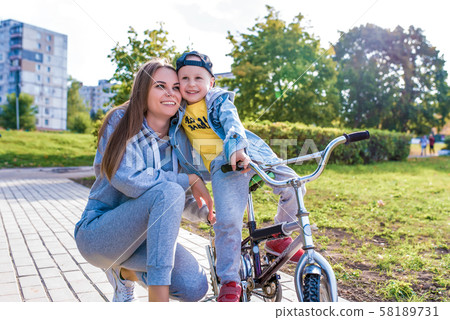 Young happy family smiling happy rejoicing, mom trains child little boy 3-5 years old child, learns 58189731