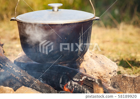 Preparing of a soup on open fire Preparing of a soup on open fire 58189920