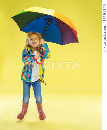 A full length portrait of a bright fashionable girl in a raincoat A full length portrait of a bright fashionable girl in a raincoat 58191549