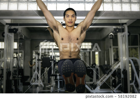 Strong bodybuilder athletic Asian man training 58192082