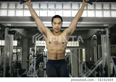 Strong bodybuilder athletic Asian man training 58192084