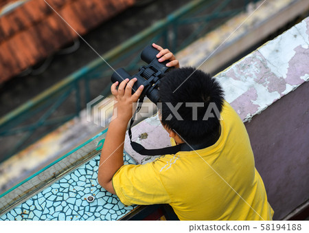 An Asian boy using the binocular An Asian boy using the binocular 58194188
