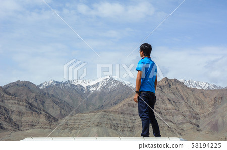A young man stands on mountain A young man stands on mountain 58194225