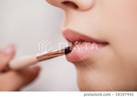 Make-up artist does makeup to a beautiful girl in a beauty salon 58197442