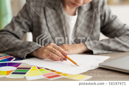 Professional tailor drawing fashion sketch at atelier 58197471