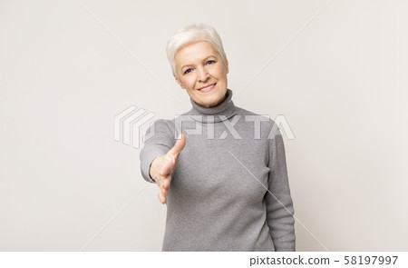 Elderly woman extending hand for handshake on camera 58197997