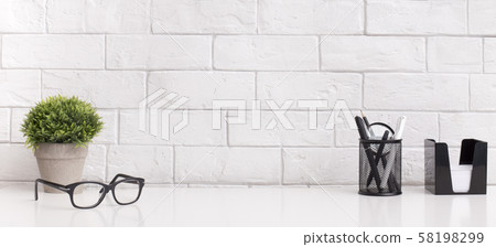 White minimal office desk table with supplies and glasses White minimal office desk table with supplies and glasses 58198299