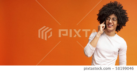 Cheerful black guy enjoying mobile talk with friend 58199046