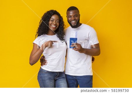 Happy young black couple holding passports and tickets Happy young black couple holding passports and tickets 58199730