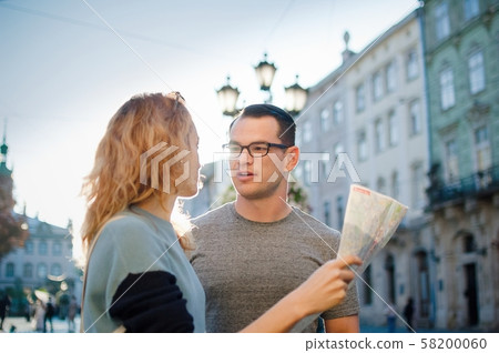 Young couple watching the city map and searching for direction early in the morning on empty ancient 58200060