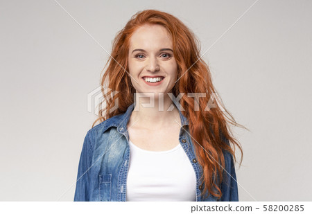 Portrait of beautiful redhead girl smiling to camera 58200285